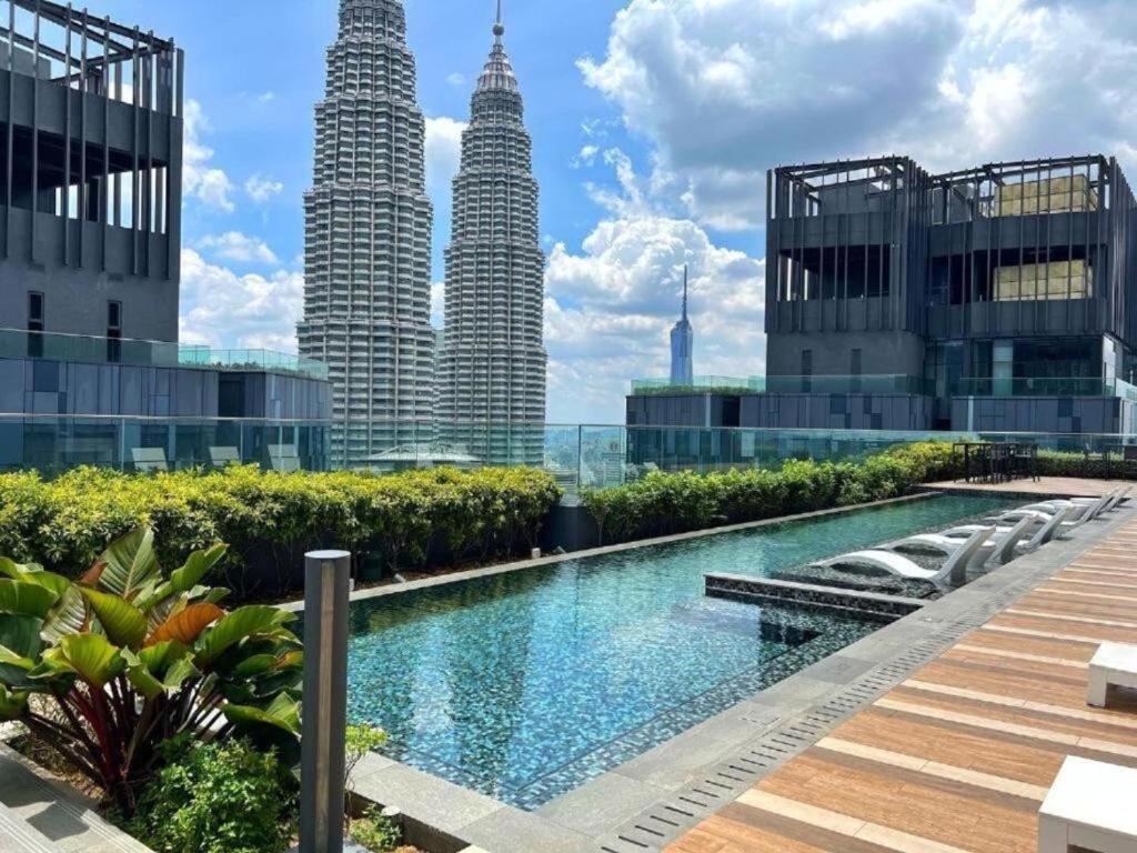 uma piscina em frente às torres gémeas Petronas em Star Residences KLCC em Kuala Lumpur