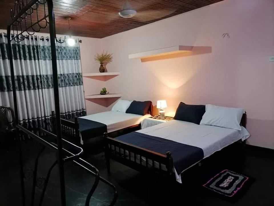 a room with two beds in a room at Kingsland Hostel in Anuradhapura