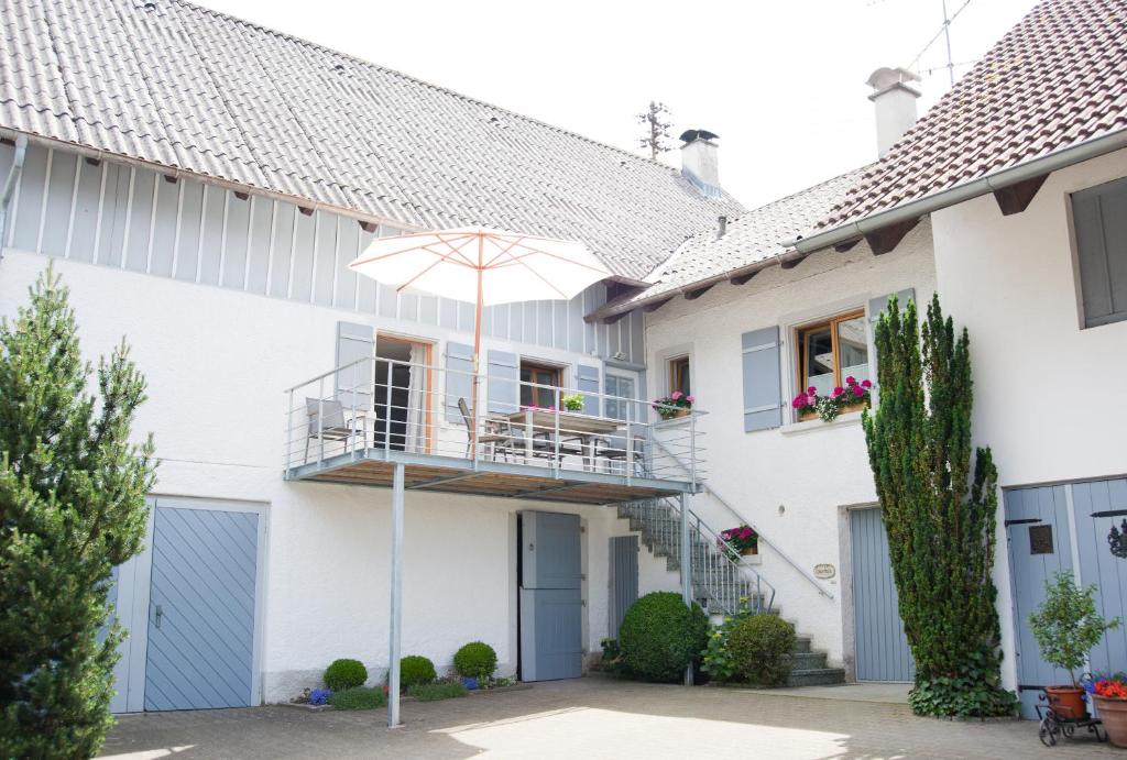 Casa blanca con balcón y sombrilla en kleines Landhaus Bodensee, en Überlingen