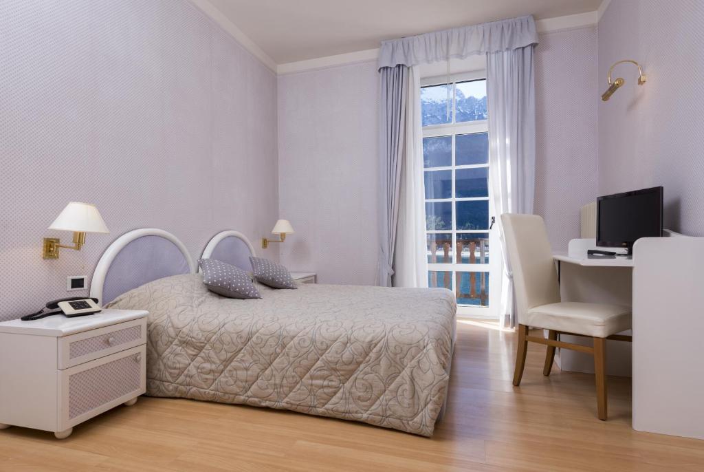 Postel nebo postele na pokoji v ubytování Grand Hotel Molveno