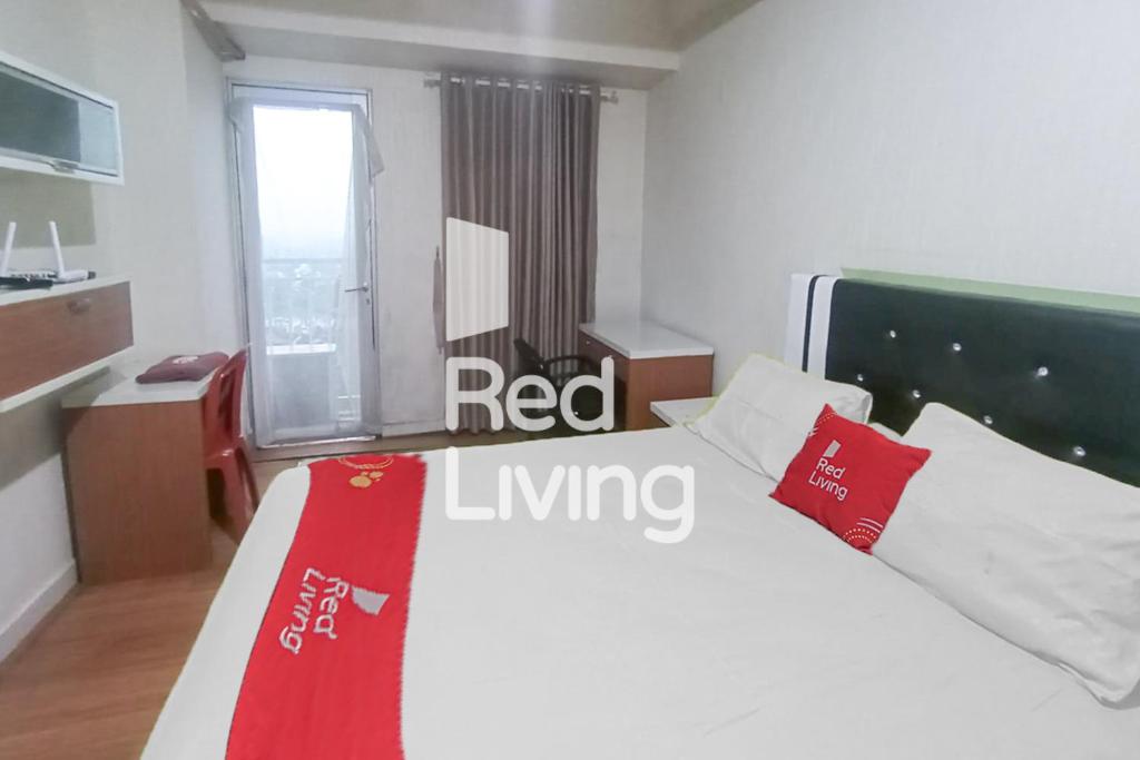 sypialnia z białym łóżkiem z czerwonymi poduszkami w obiekcie RedLiving Apartemen Easton Park Jatinangor - Yunus w mieście Sumedang