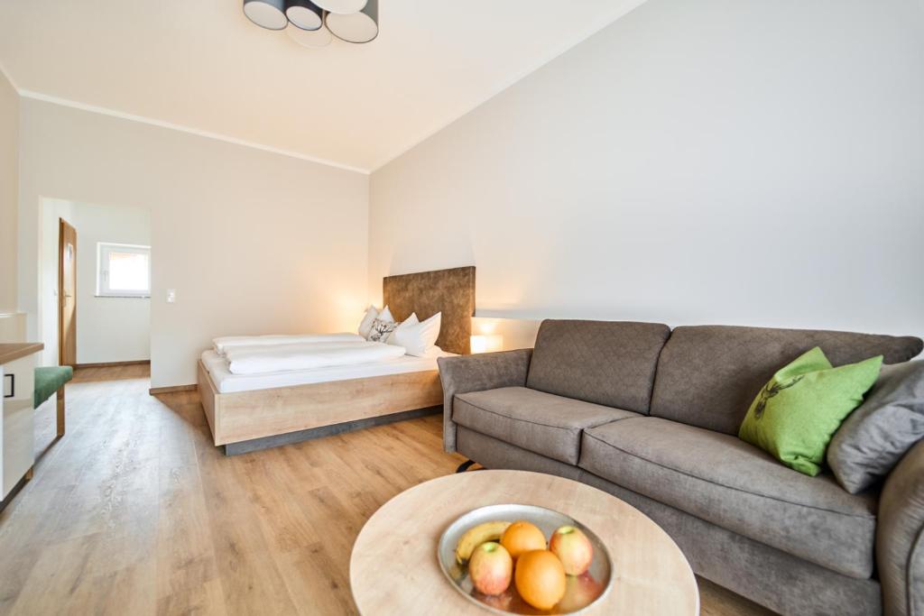 Haarbach的住宿－Wirt z´Uttlau Familienhotel Höng，客厅配有沙发和一碗水果
