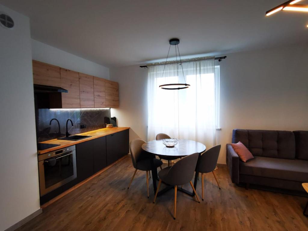 a kitchen and dining room with a table and a couch at Akacjowy Apartament in Sianozety