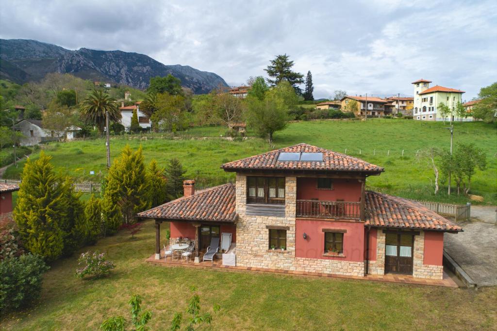 a small house with a balcony on a green field at La Coqueta Del Sueve in Arriondas
