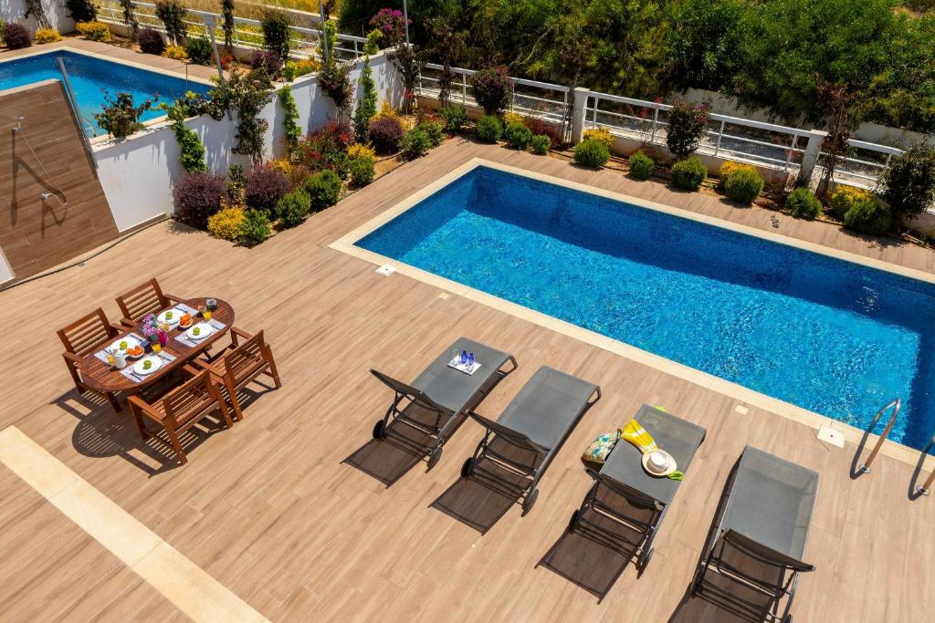uma vista sobre um pátio com uma mesa e cadeiras e uma piscina em Napa Bay View Villa 3 em Agia Napa