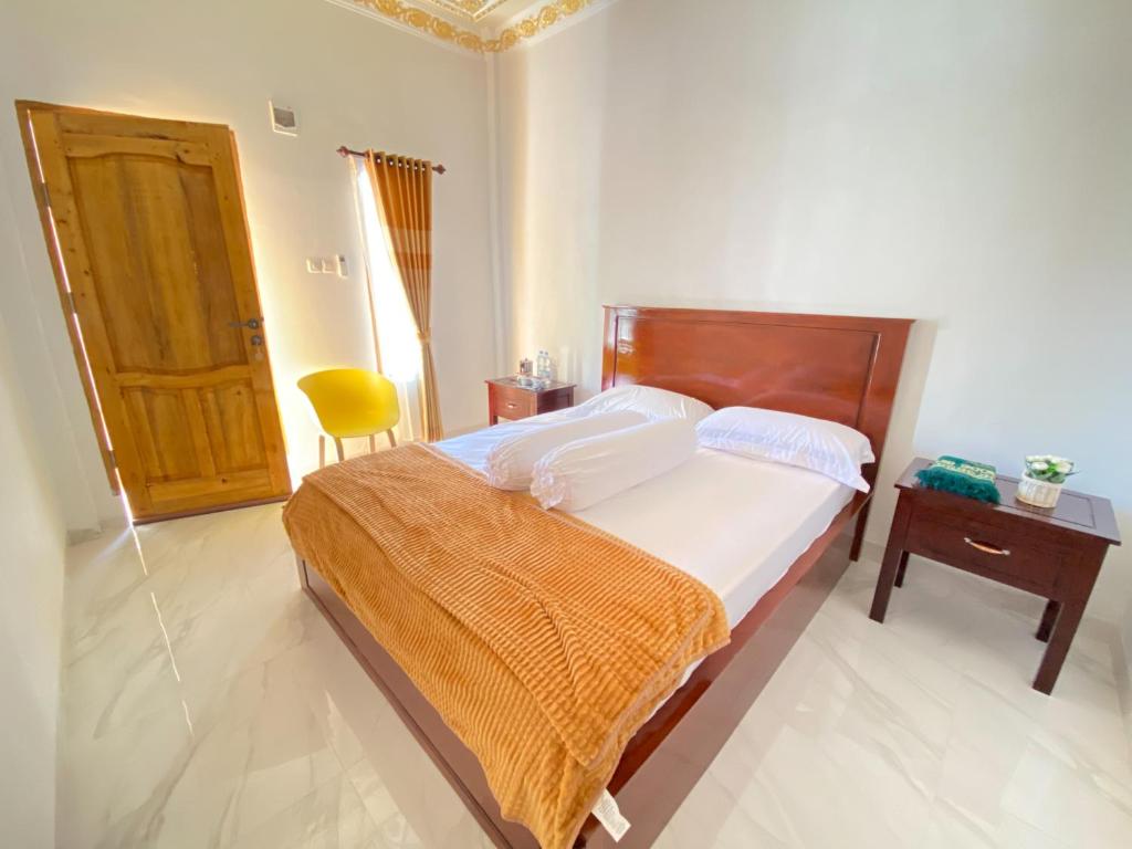 a bedroom with a bed and a table and a door at Rumah Windy Guest House Bira in Bira