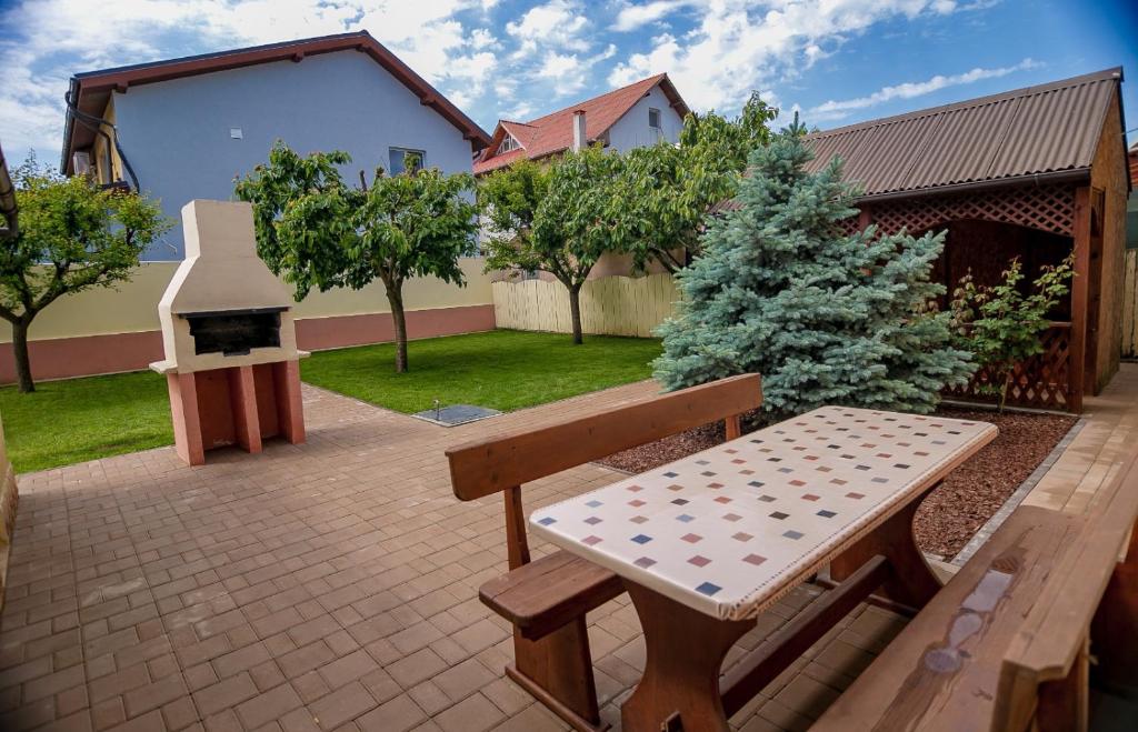 a picnic bench and a grill in a backyard at Casa Bibi in 2 Mai