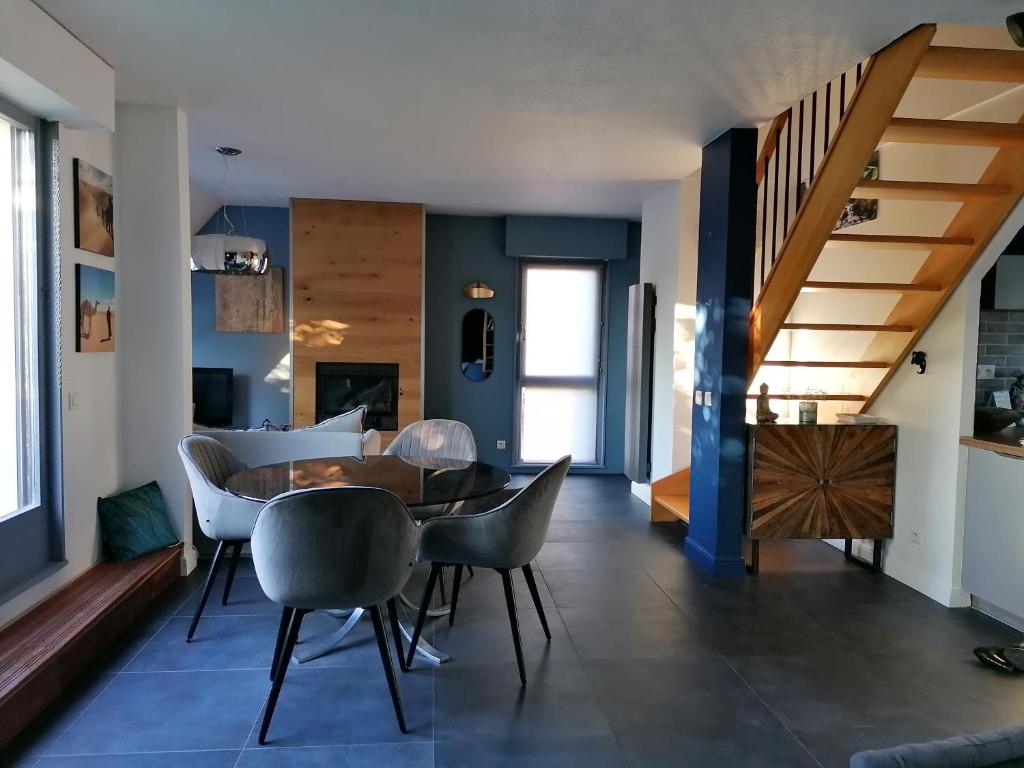 een eetkamer en een woonkamer met een tafel en stoelen bij Spacieux loft en duplex in Straatsburg