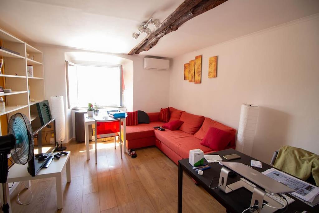 ein Wohnzimmer mit einem roten Sofa und einem Tisch in der Unterkunft Historic house close to station in Genua