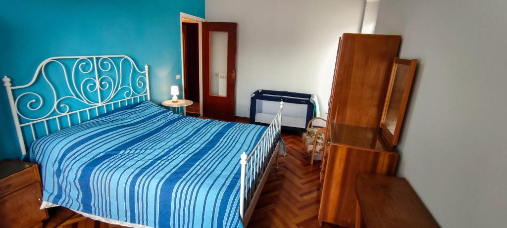 a bedroom with a blue and white bed and a dresser at Le Caravelle in Rapallo