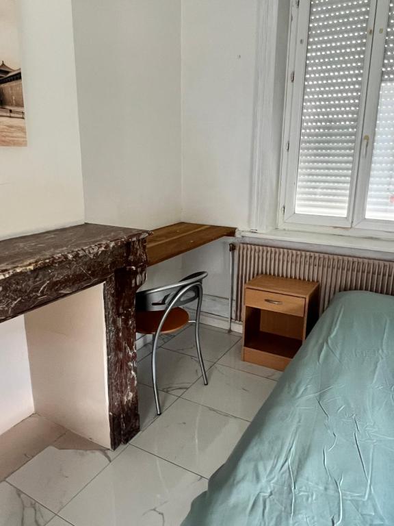 a room with a desk and a bed and a table at Room in Calais