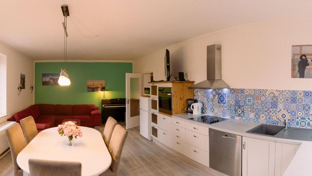 eine Küche und ein Wohnzimmer mit einem Tisch und einem Sofa in der Unterkunft Haus Oveney in Bochum
