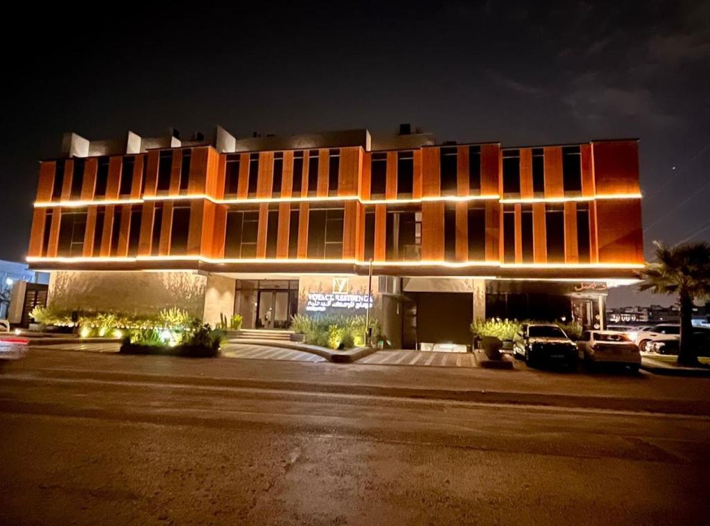 فوياج ريسيدنس في الرياض: مبنى في الليل فيه سيارات تقف امامه