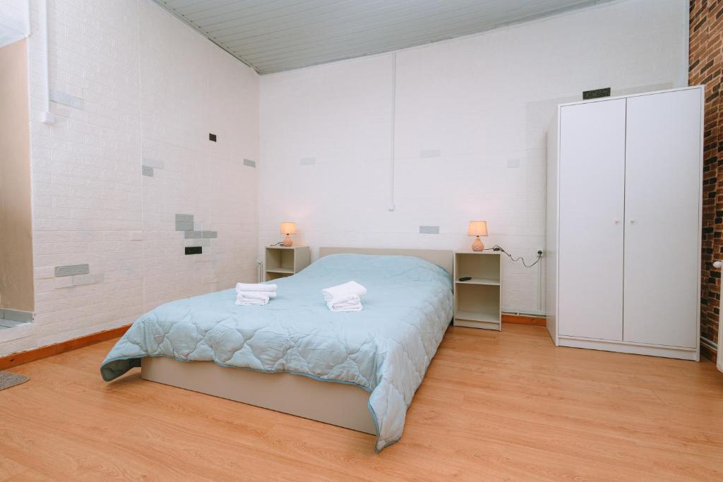 a white bedroom with a bed and two lamps at Cozy Home Archanes in Archanes