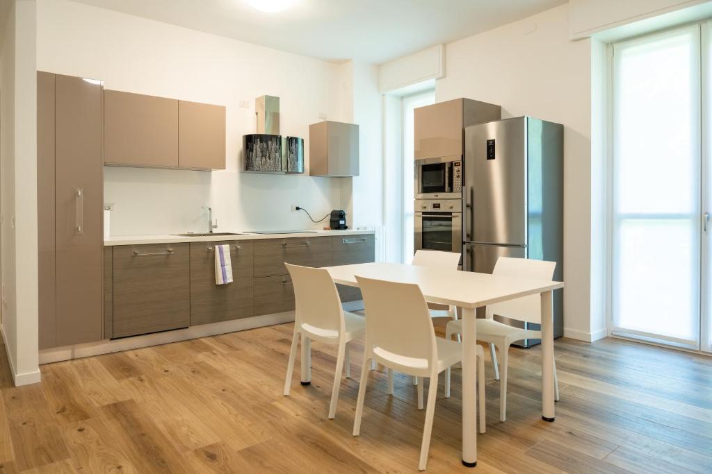 a kitchen with a table and chairs and a refrigerator at 15min metro Duomo - RHO fiera - Skyscraper Kitchen in Milan