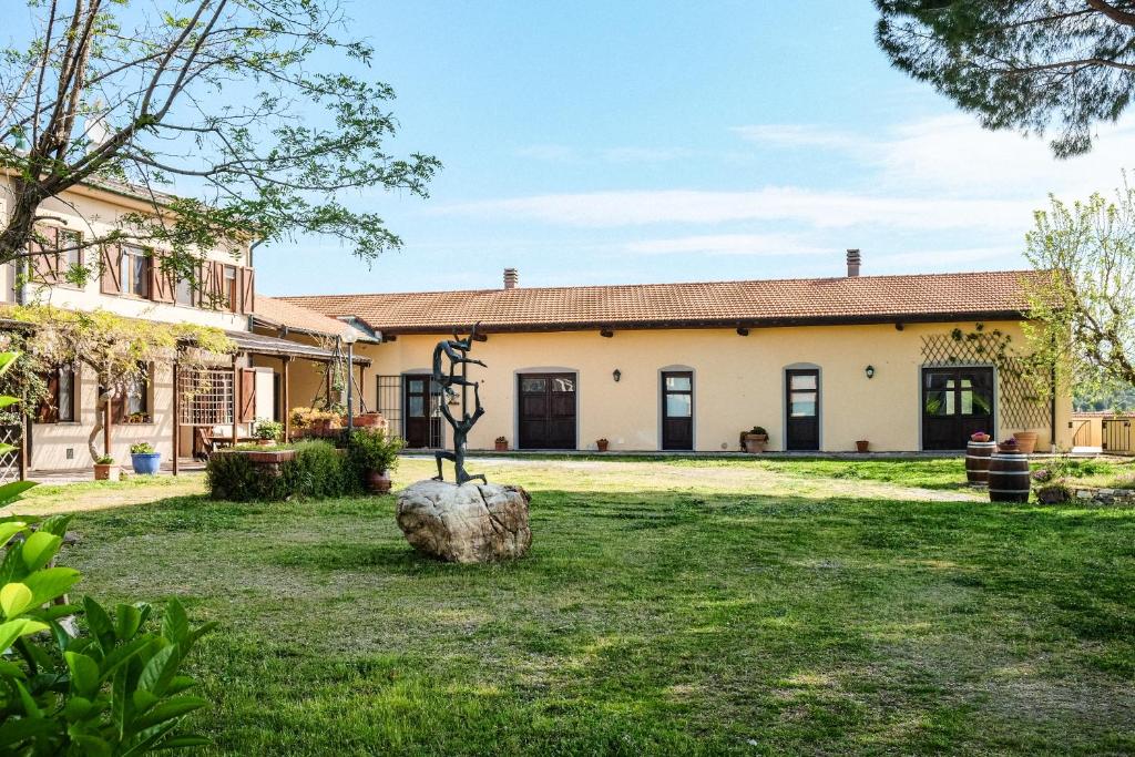 a house with a statue in the yard at Agriturismo biologico Bulichella in Suvereto