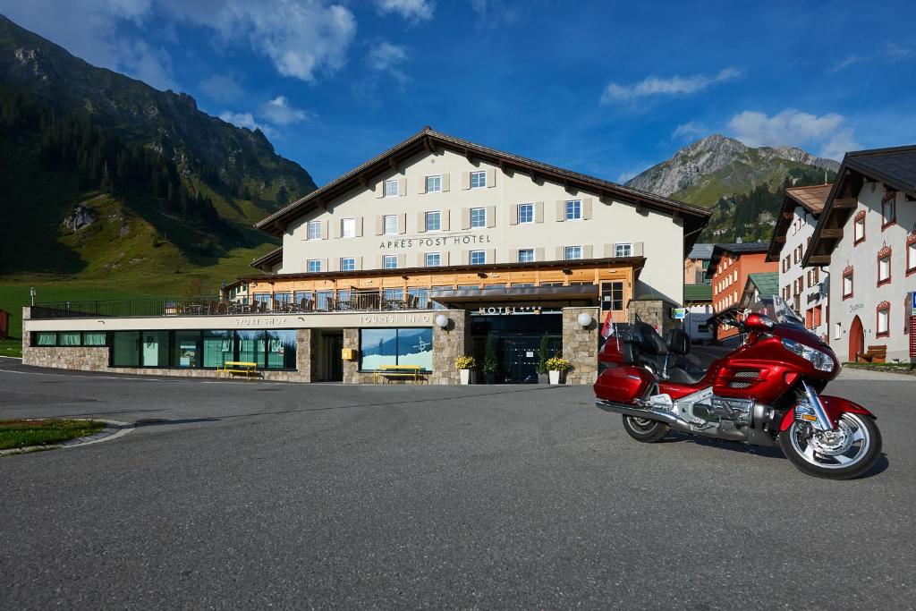 una moto rossa parcheggiata di fronte a un edificio di Après Post Hotel a Stuben am Arlberg