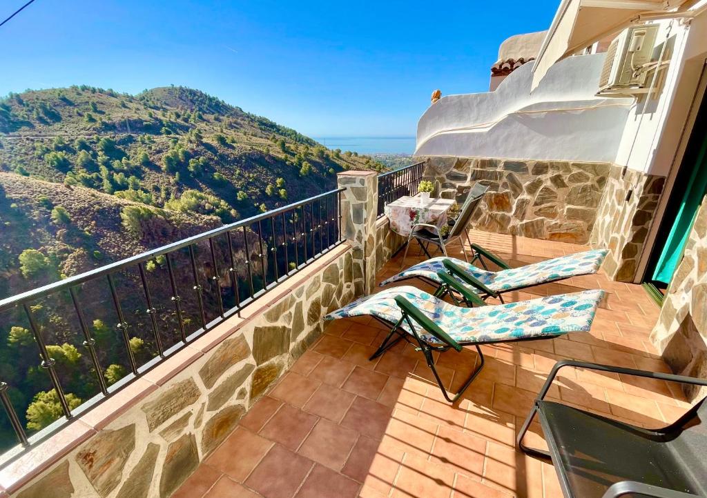 einen Balkon mit Stühlen und Bergblick in der Unterkunft Apartamentos Axarquia , Frigiliana, terraza privada con vistas a la montaña rio y al mar in Frigiliana