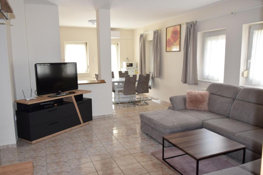a living room with a couch and a flat screen tv at Anita Apartman in Zalakaros