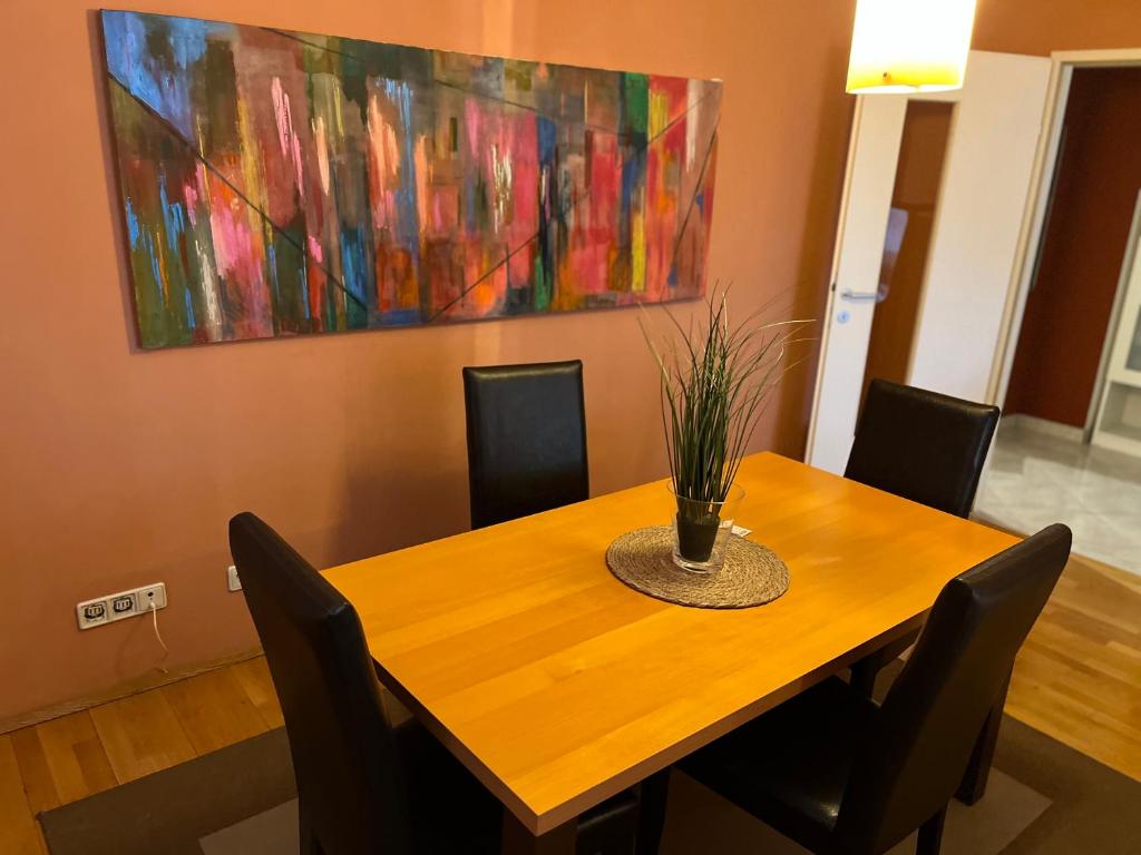 une table à manger avec des chaises et un tableau mural dans l'établissement Stelius Wien, à Vienne