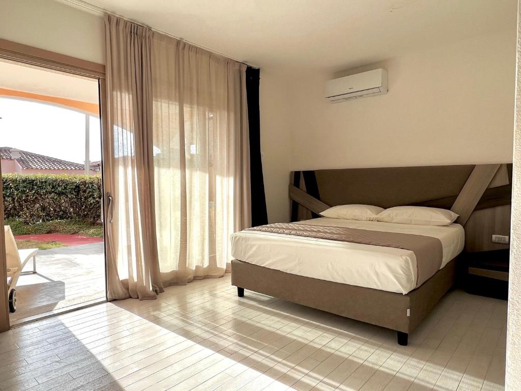 a bedroom with a bed and a sliding glass door at Suite con giardino in La Maddalena