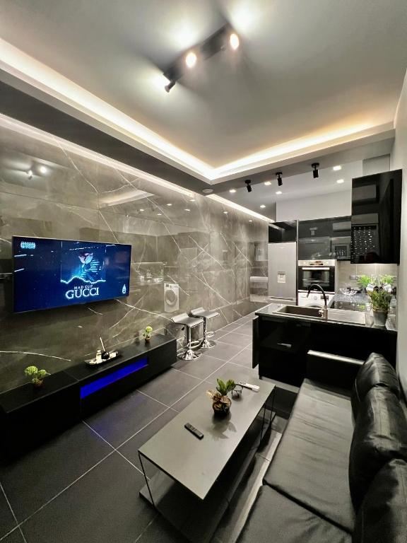 a living room with a tv on a wall at Luxury Black and White Interior Apartments & Rooftop Terrace in Kalamata