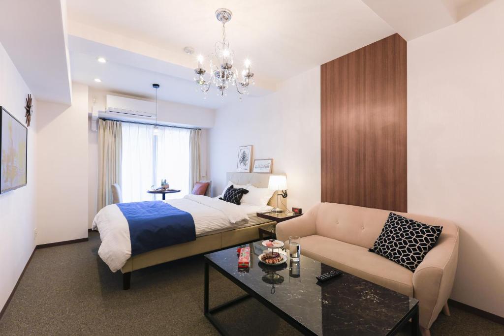 a hotel room with a bed and a couch at LEOPARD Shinsaibashi in Osaka