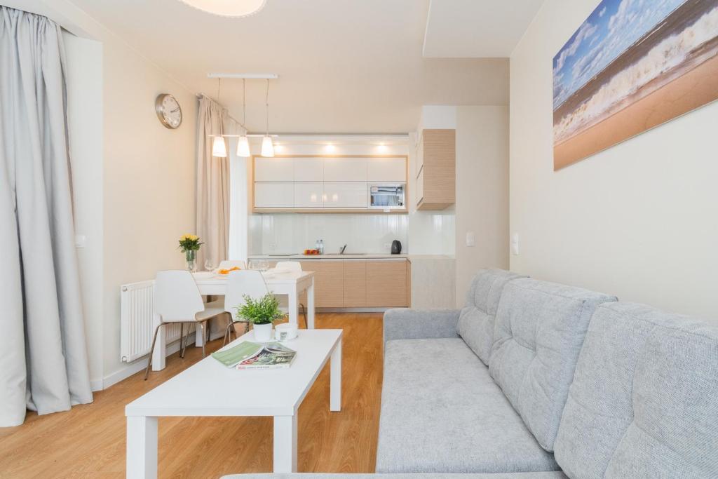 uma sala de estar com um sofá e uma mesa em Apartamenty NCNK Marina Kąty Rybackie em Kąty Rybackie