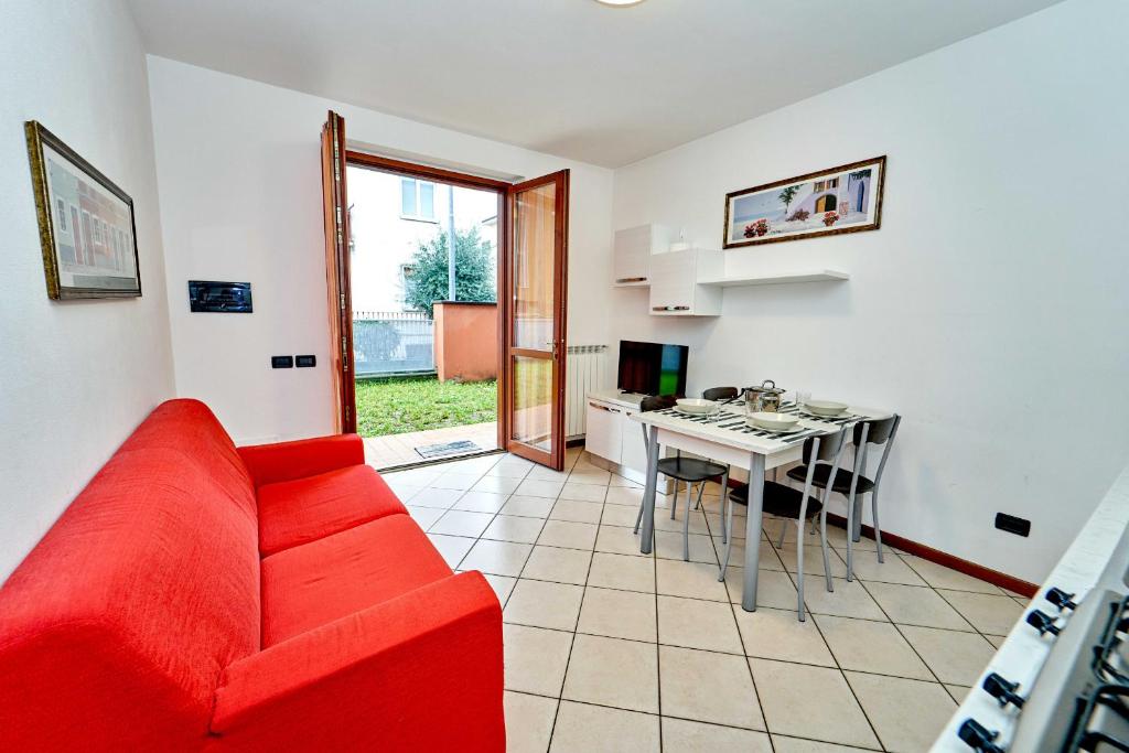een woonkamer met een rode bank en een tafel bij Affittimoderni Bergamo Curno - CUMA8 in Curno