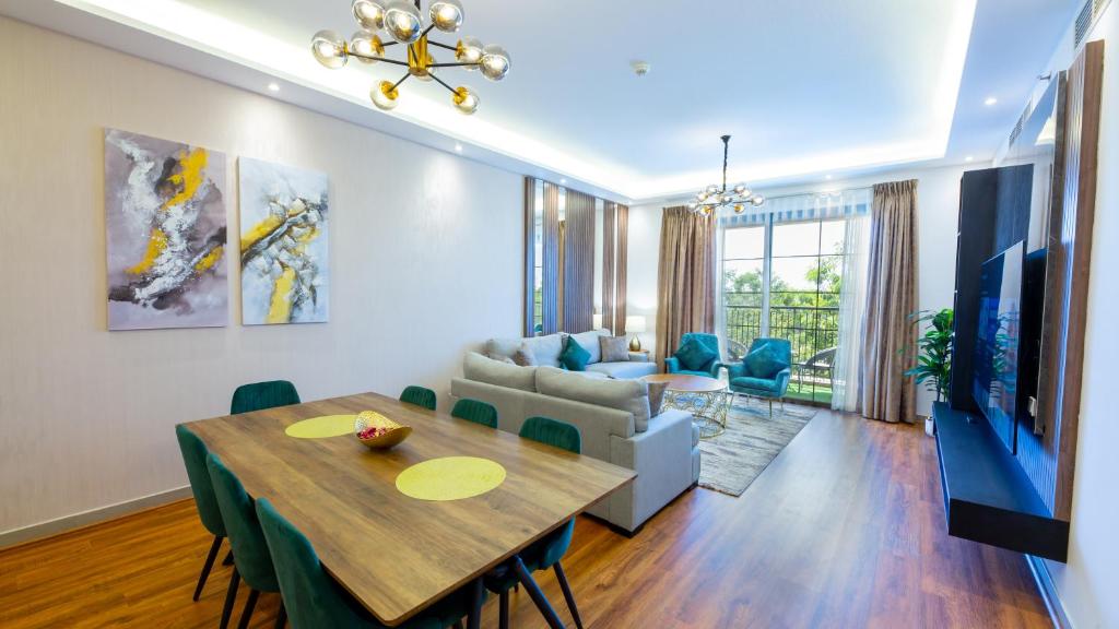 GOODWOOD SUITES HOMES VACATION في دبي: غرفة طعام وغرفة معيشة مع طاولة وأريكة