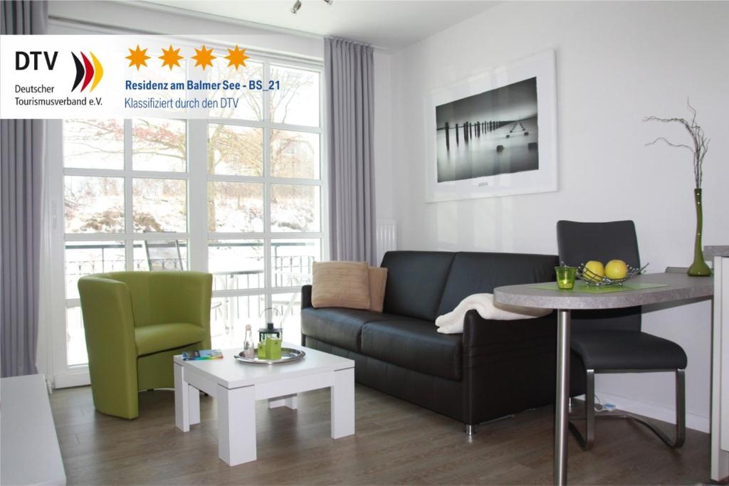 een woonkamer met een bank en een tafel bij Residenz am Balmer See - Kleine Auszeit - BS 21 mit Wellnessbereich in Balm
