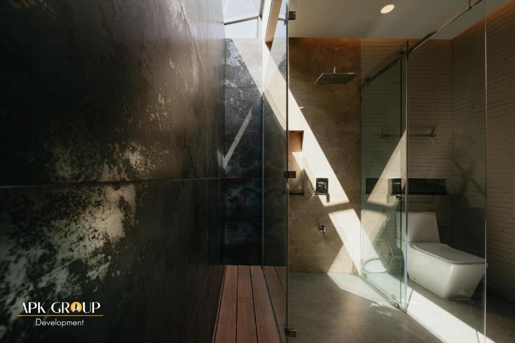 uma casa de banho com um WC e uma cabina de duche em vidro. em H1 Pool Villa em Chiang Mai