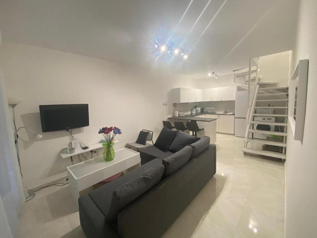 a living room with a couch and a table with a tv at DreamIsland Maisonette Protaras in Paralimni