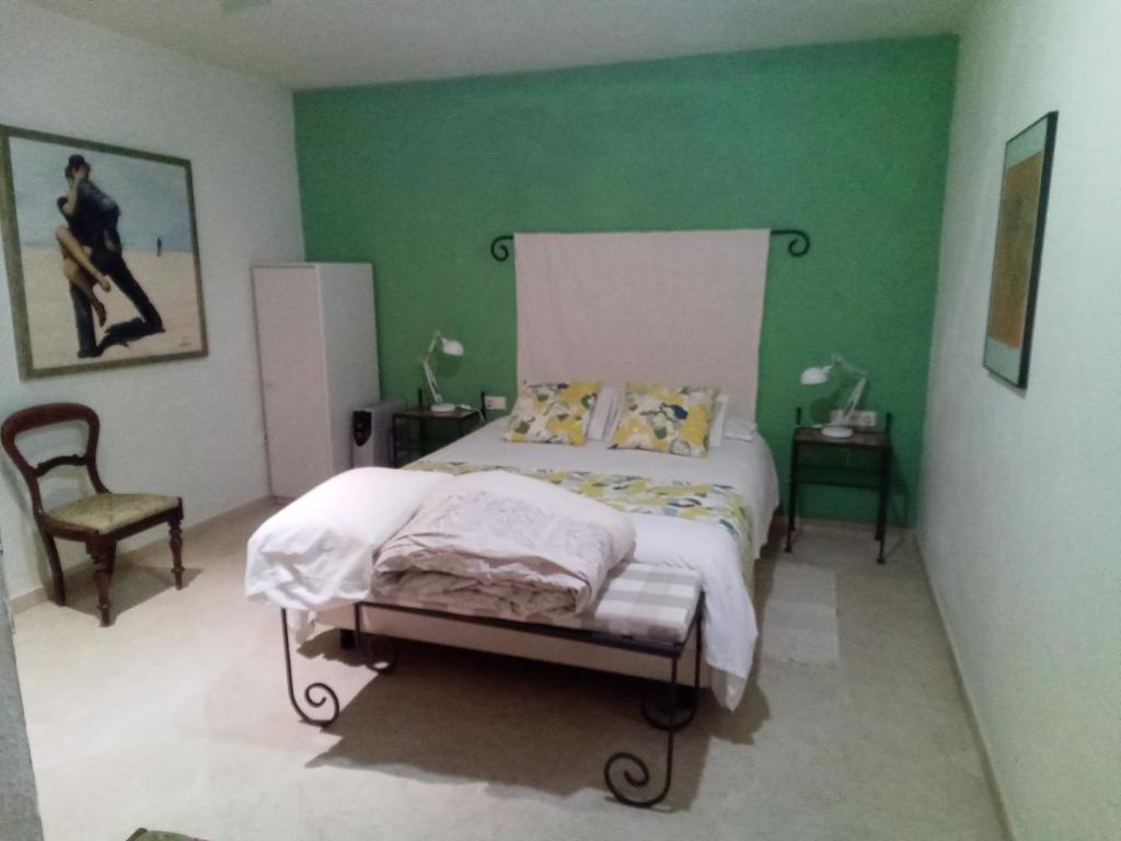 sypialnia z łóżkiem i zieloną ścianą w obiekcie Casa Romana w mieście Coín