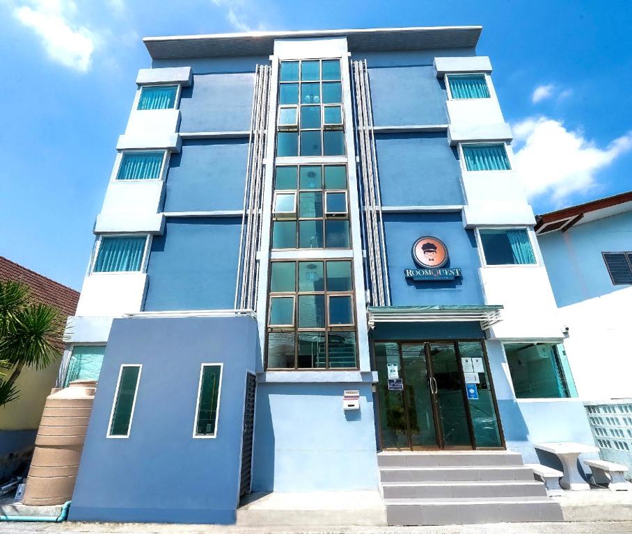 a blue building with a sign on it at RoomQuest Suvarnabhumi Ladkrabang 42 in Bangkok