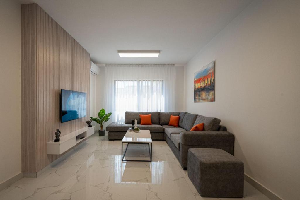 sala de estar con sofá y mesa en Al Kawther Hotel Apartments en Amán