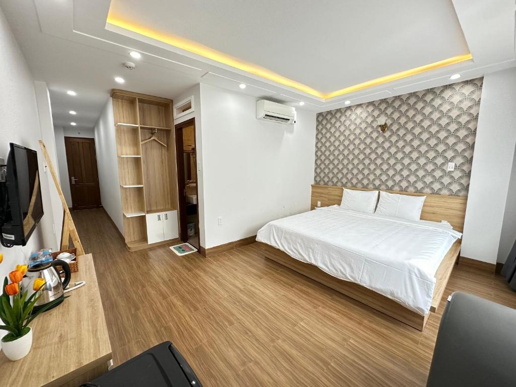 1 dormitorio con 1 cama y TV en The Land Hotel & Apartment en Vung Tau