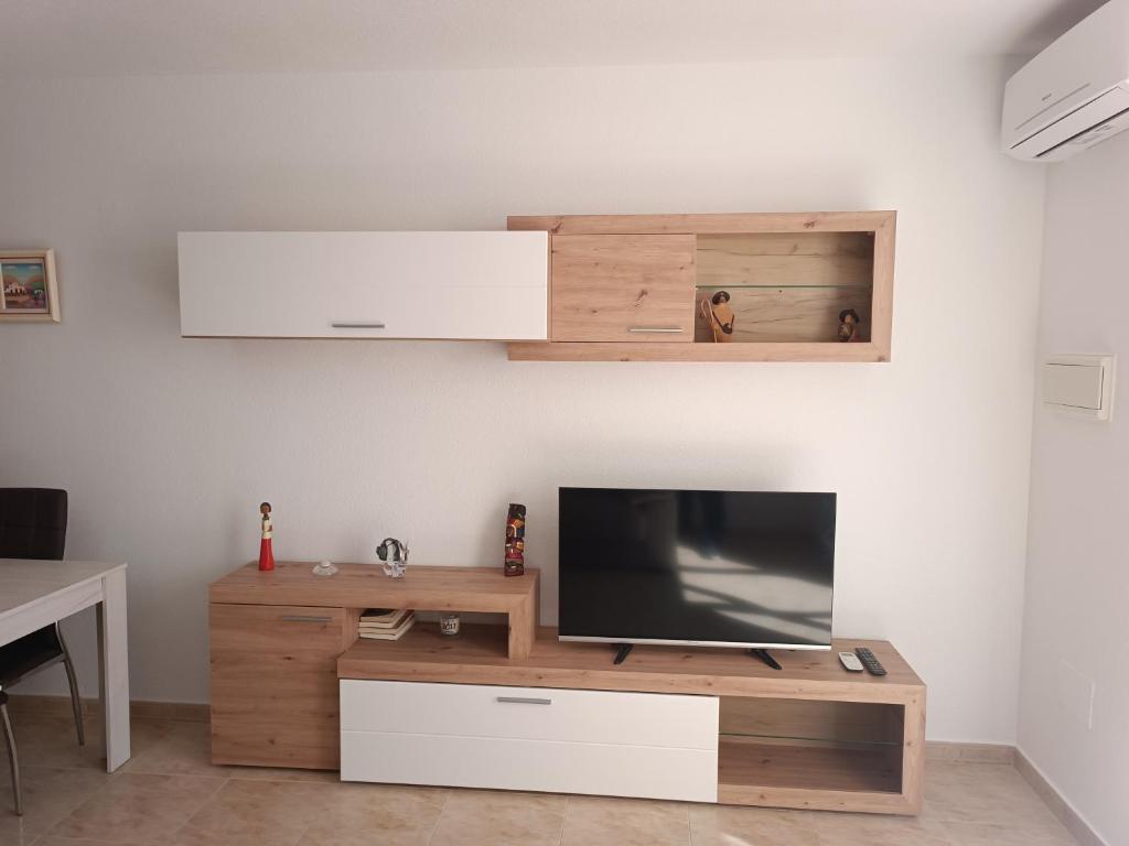 salon z telewizorem w drewnianym centrum rozrywki w obiekcie Vera Natura Apartamento Alba w mieście Vera