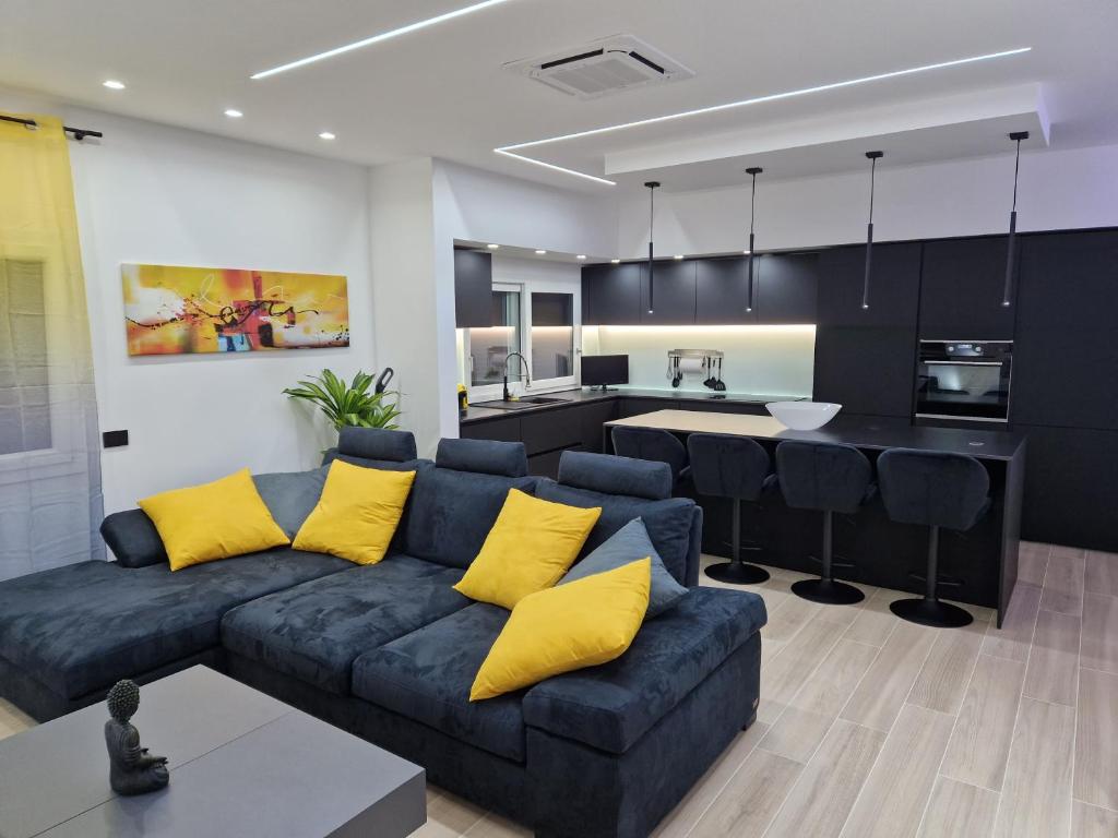 uma sala de estar com um sofá azul e almofadas amarelas em LA CASA DI TIAGO em Palermo