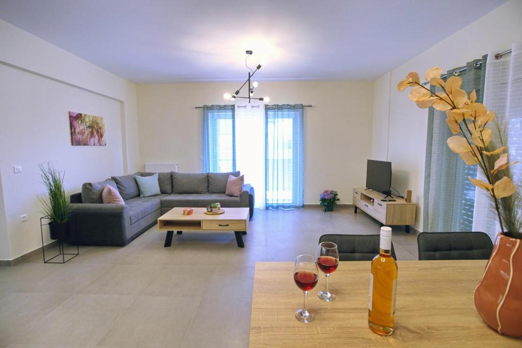 a living room with a couch and two glasses of wine at 90° - Ninety Degrees in Nafplio