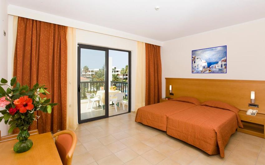Postel nebo postele na pokoji v ubytování Tigaki Beach Hotel