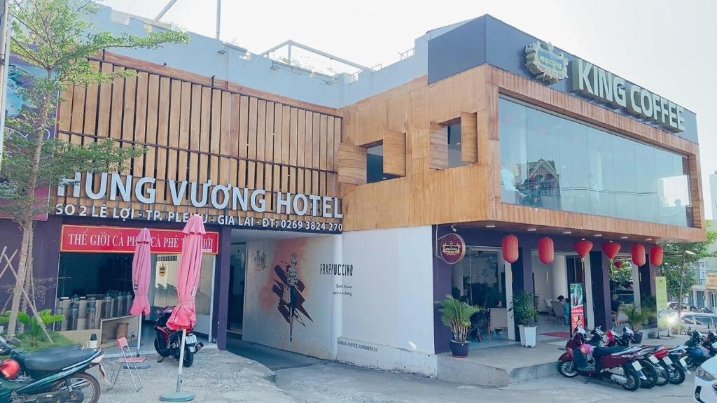een gebouw met motoren die ervoor geparkeerd staan bij Hung Vuong Hotel in Pleiku