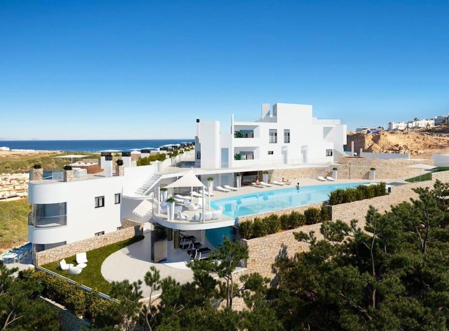 ein großes weißes Haus mit Pool und Meer in der Unterkunft R100 - APARTMENT WITH WIFI AND SEA VIEW - SUKHA in Gran Alacant