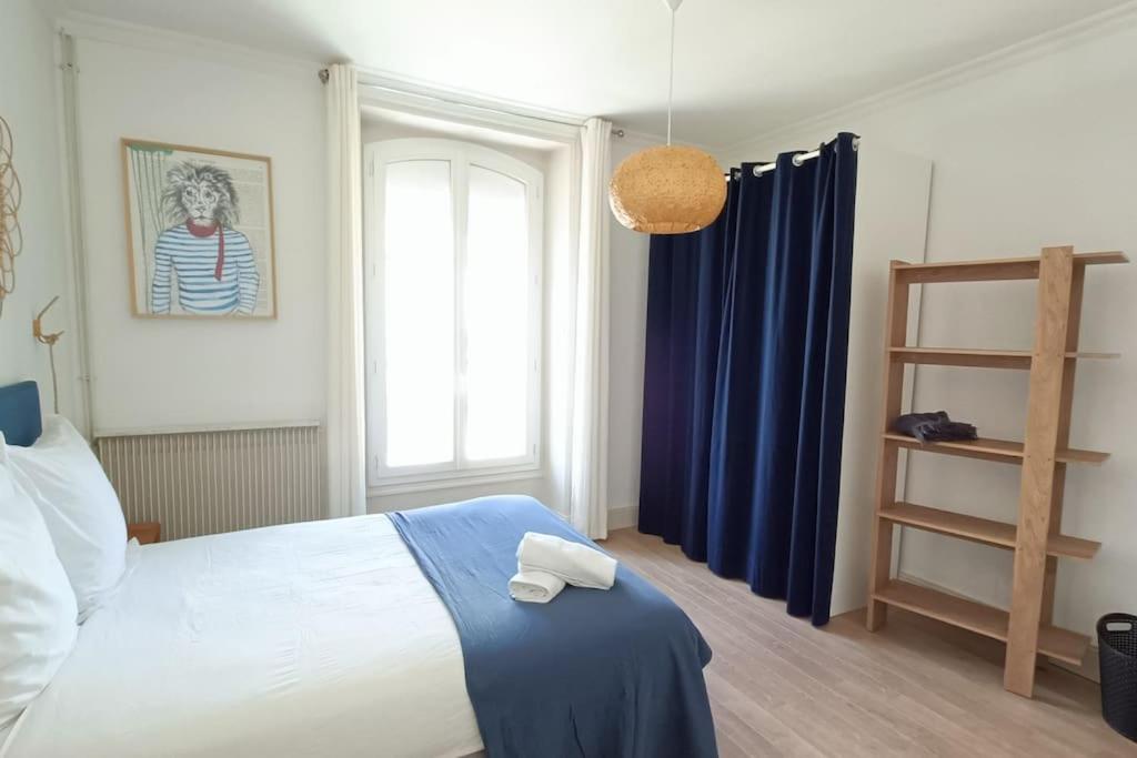 a bedroom with a bed with blue curtains and a window at Le Bon Repos-ESA&#47;UCO avec jardin in Angers