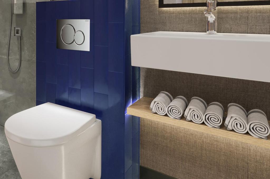a bathroom with a toilet and a sink and a toilet paper holder at Erzurumlu Hotel in Kilyos