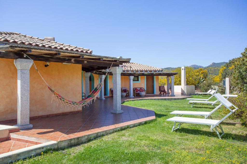 a patio with a hammock on the side of a house at Hotel Stefania Boutique Hotel by the Beach in Olbia