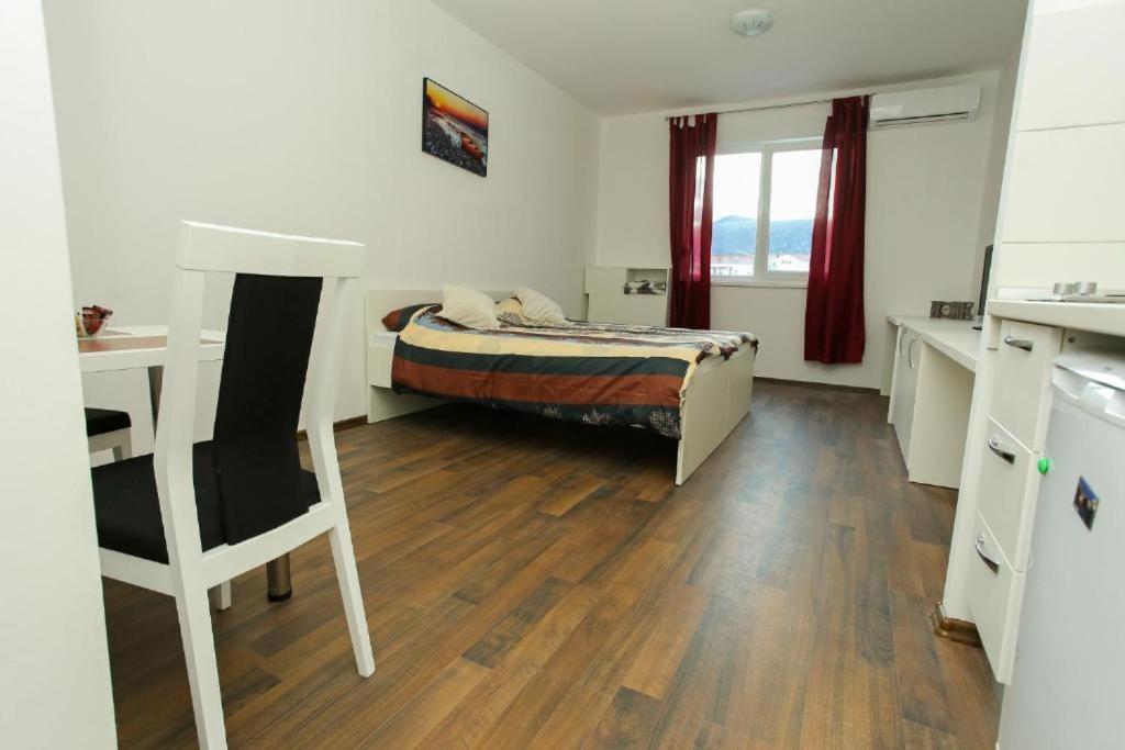 a bedroom with a bed and a desk and a chair at City Apartments in Mostar