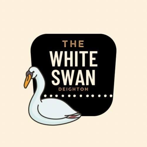 Ein weißer Schwan ist neben einem schwarzen Becher. in der Unterkunft The White Swan Deighton in York