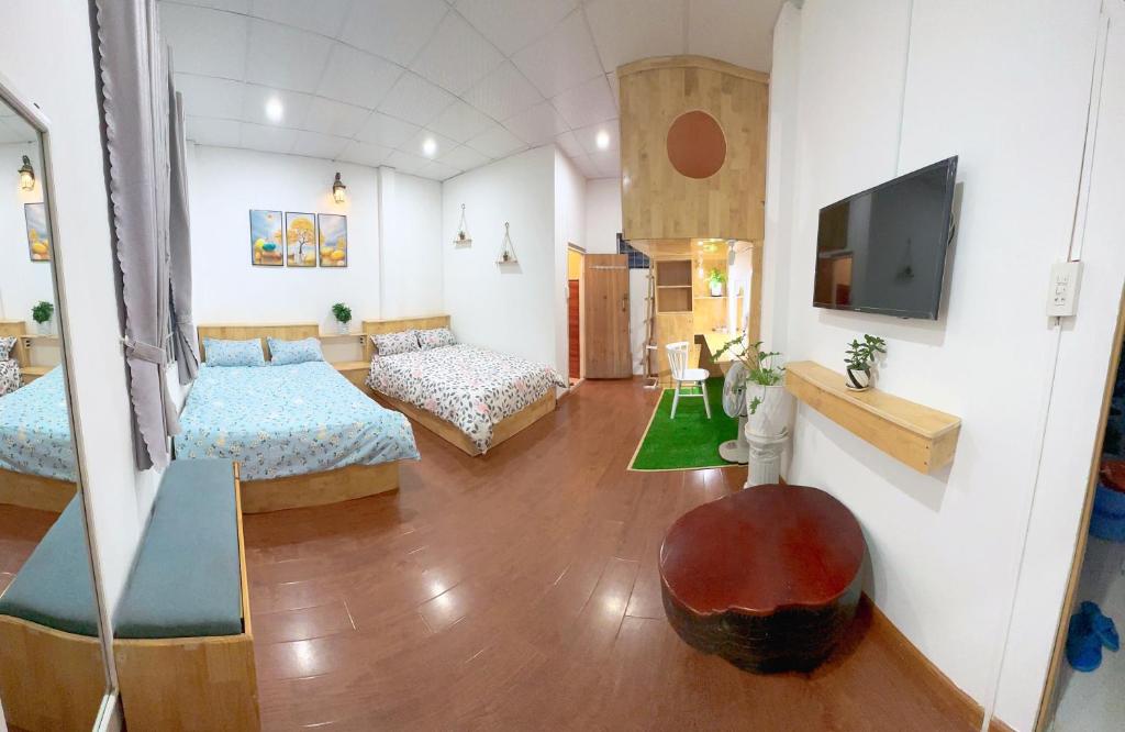 Habitación con 2 camas y TV de pantalla plana. en Suri's House Homestay, en Da Lat