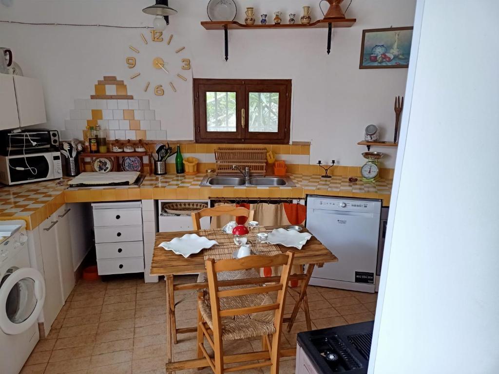 een keuken met een tafel met stoelen en een wastafel bij La casina di Alicia in Montenero di Bisaccia
